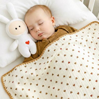 Bébé dormant paisiblement avec une couverture bébé en coton bio