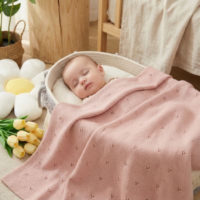 Couverture bébé douce rose poudré en coton avec broderie ajourée pour nouveau-né endormi dans berceau blanc