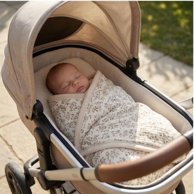 Couverture bébé à fleurs vintage protégeant nouveau-né endormi dans poussette lors promenade extérieure