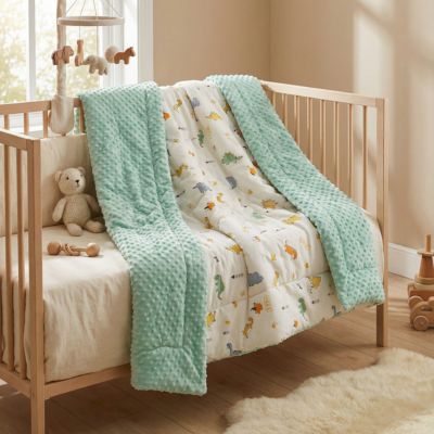 Couverture bébé texture menthe dinosaures sur lit bois chambre enfant claire"