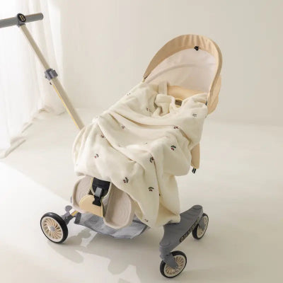 Poussette recouverte d’une couverture bébé à motif de petites cerises