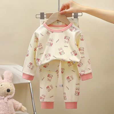 Pyjama bébé deux pièces blanc cassé avec motifs lapin et poignets contrastés roses, présenté sur cintre