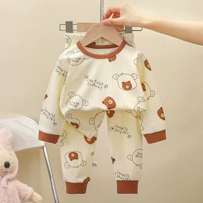 Pyjama bébé ensemble deux pièces crème avec imprimé ourson, présenté sur cintre avec peluche