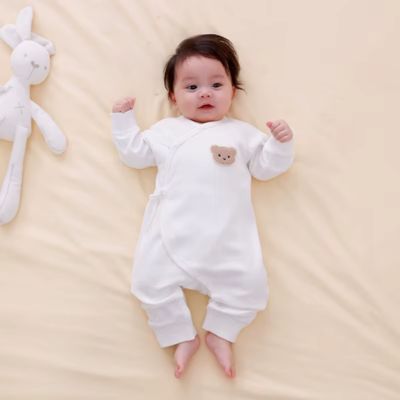 Pyjama bebe blanc motif ourson brodé, bébé allongé avec peluche