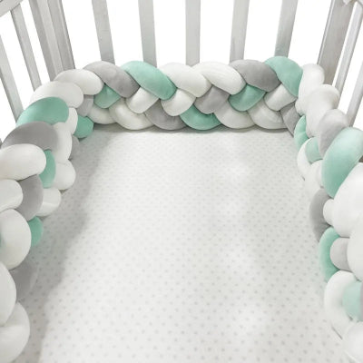 Tresse de lit 3m aux couleurs vert, blanc et gris, posée dans un lit à barreaux